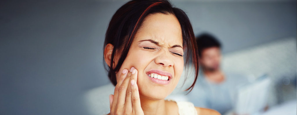 Woman in pain because of grinding teeth