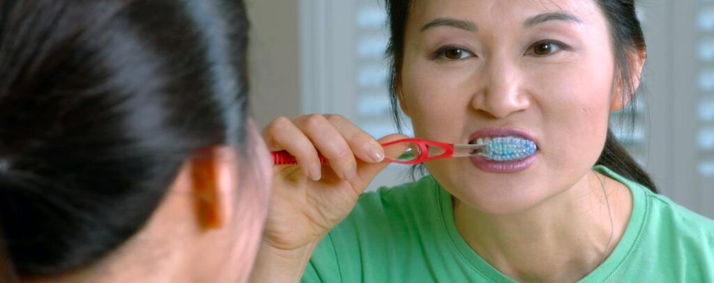woman brushes teeth after being sick with braces