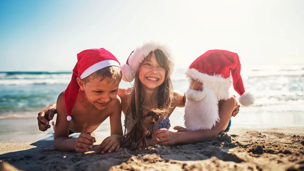 kids pose on the beach wearing santa hats and listen in to stocking stuffer ideas