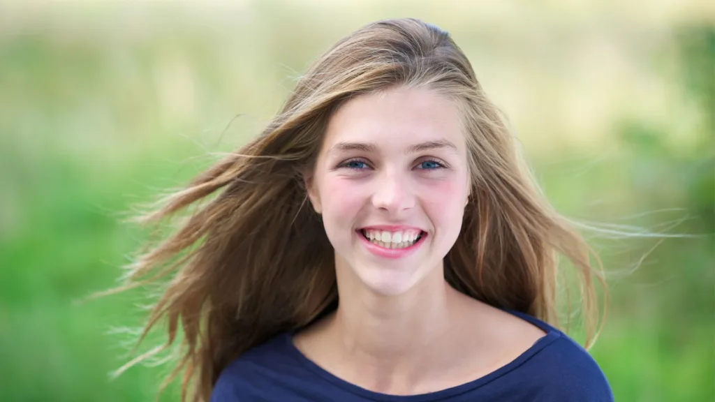 teen smiles after using whitening toothpaste with braces