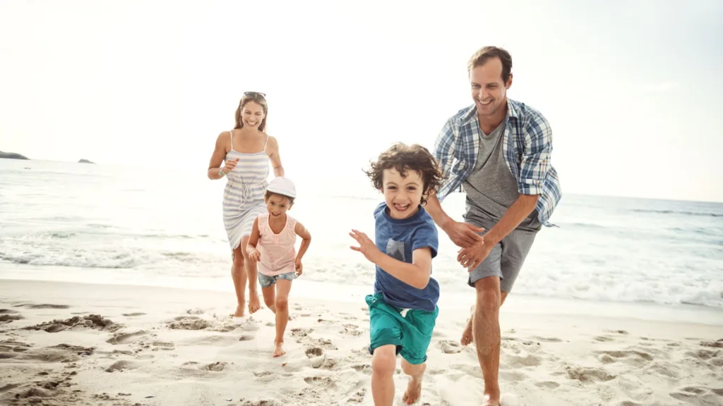 family chases each other on the beach and talks facts about gum disease