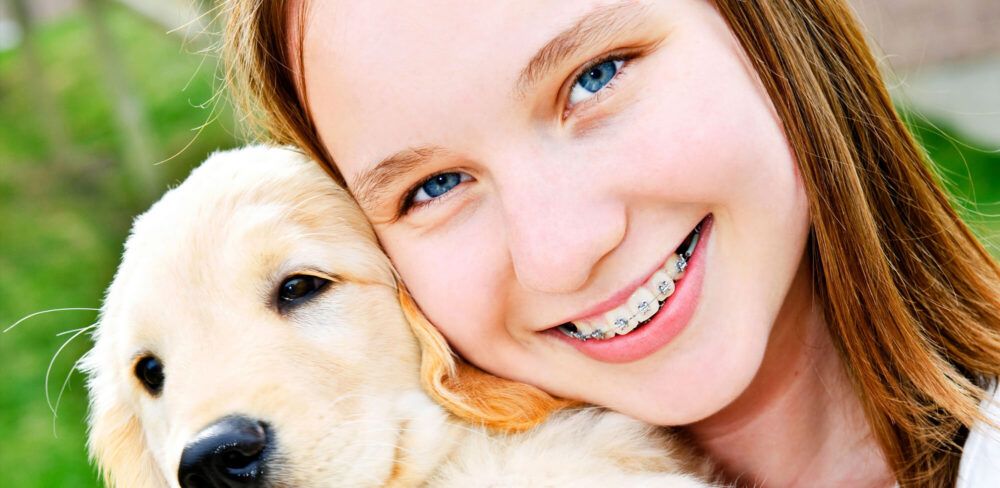 Girl with a puppy on her first week with braces