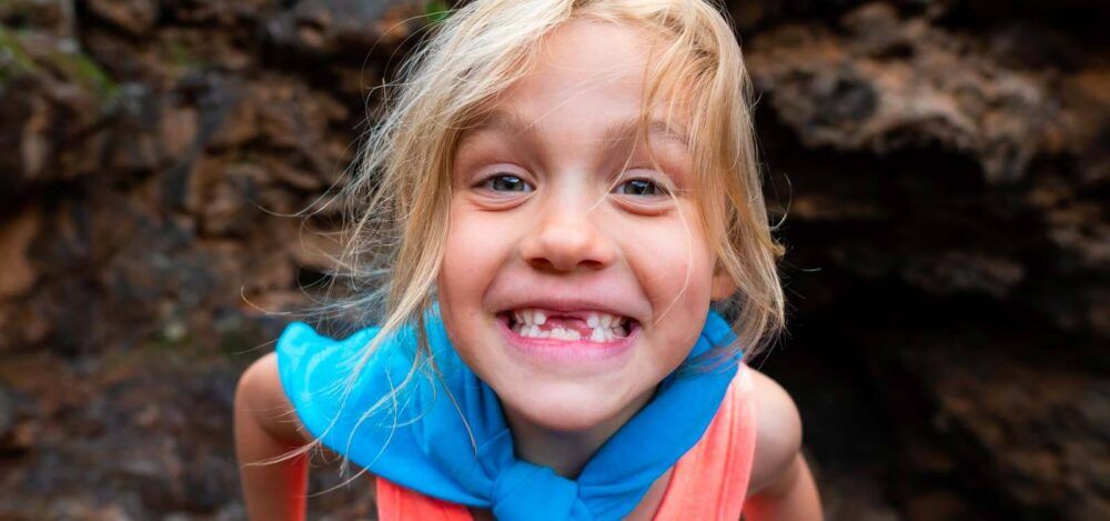 girl smiles after learning the signs you need braces