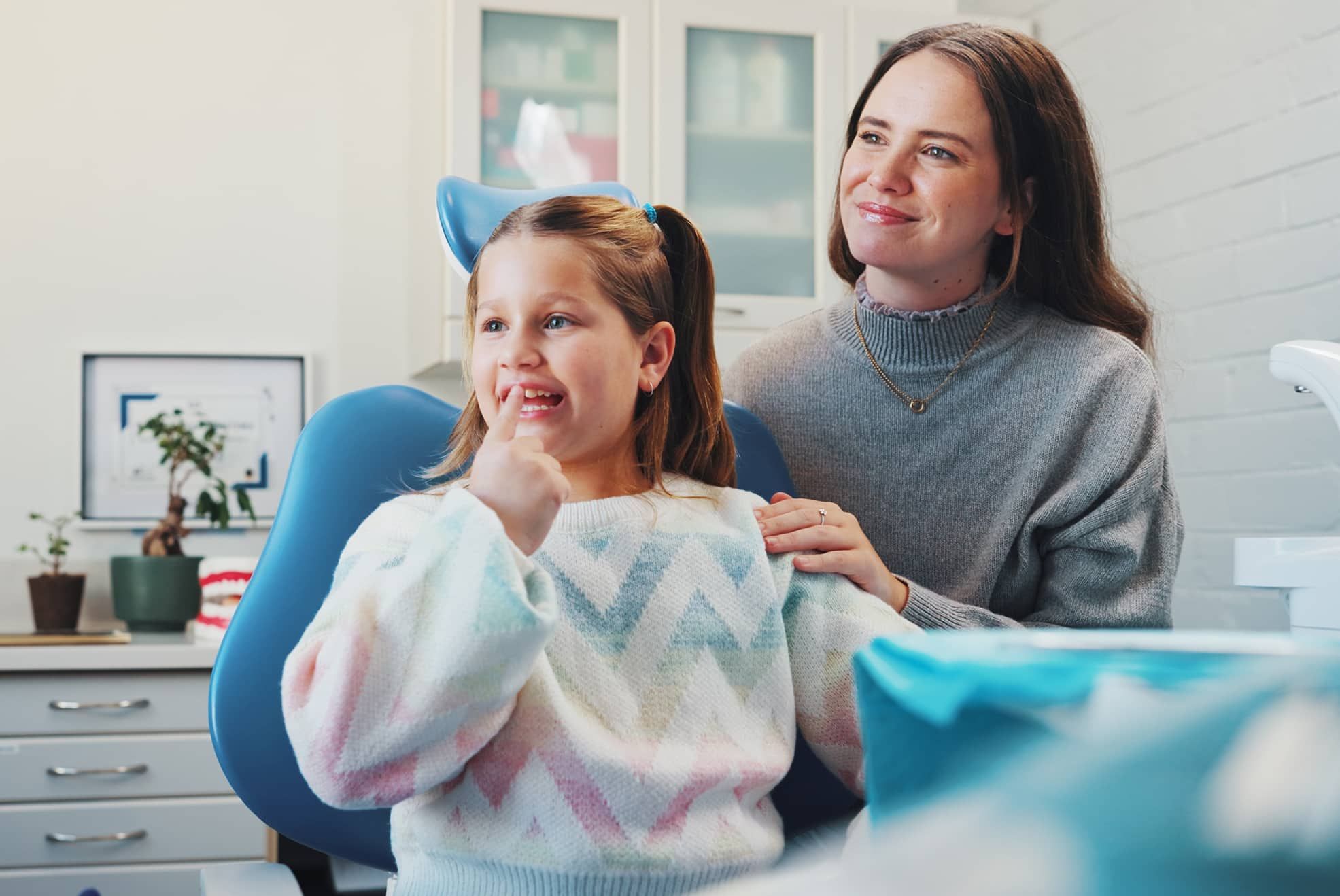 Child, dentist and show tooth at dental consultation with orthodontist for advice or cleaning.